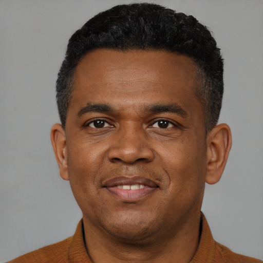 Joyful black young-adult male with short  black hair and brown eyes