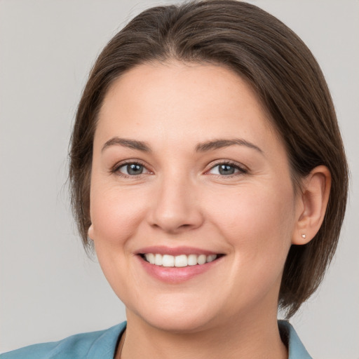 Joyful white young-adult female with medium  brown hair and grey eyes