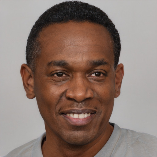 Joyful black adult male with short  black hair and brown eyes