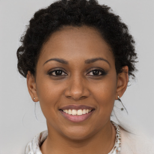 Joyful black young-adult female with short  brown hair and brown eyes