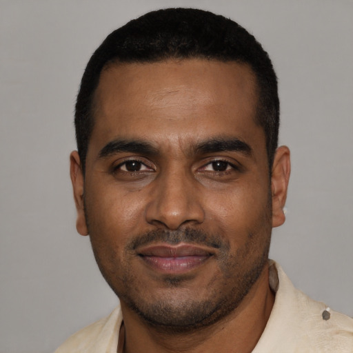Joyful black young-adult male with short  black hair and brown eyes