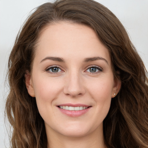 Joyful white young-adult female with long  brown hair and green eyes