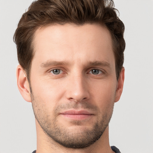 Joyful white young-adult male with short  brown hair and grey eyes