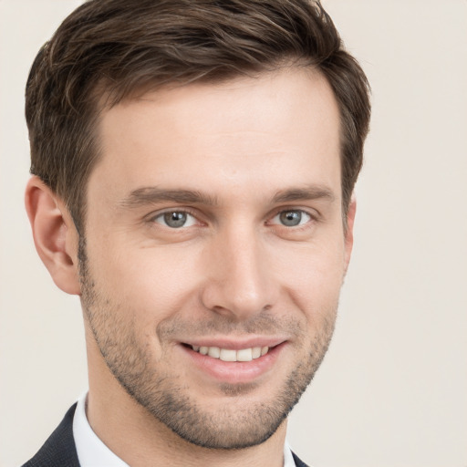 Joyful white young-adult male with short  brown hair and grey eyes