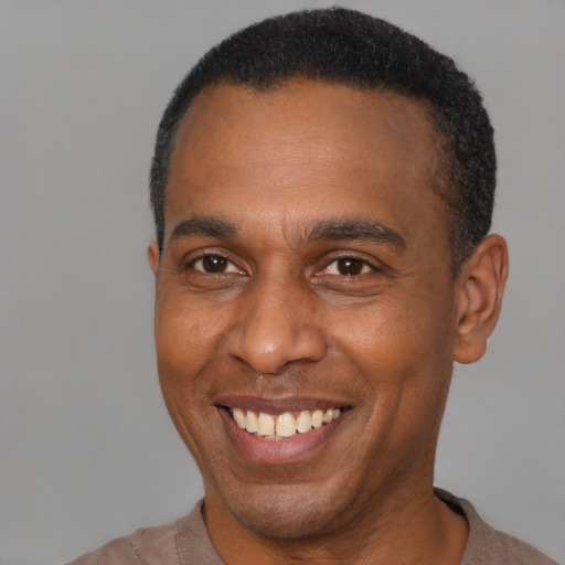 Joyful latino adult male with short  brown hair and brown eyes
