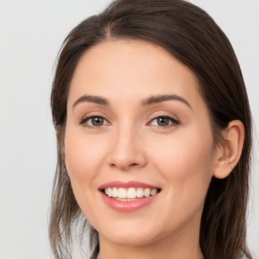 Joyful white young-adult female with long  brown hair and brown eyes