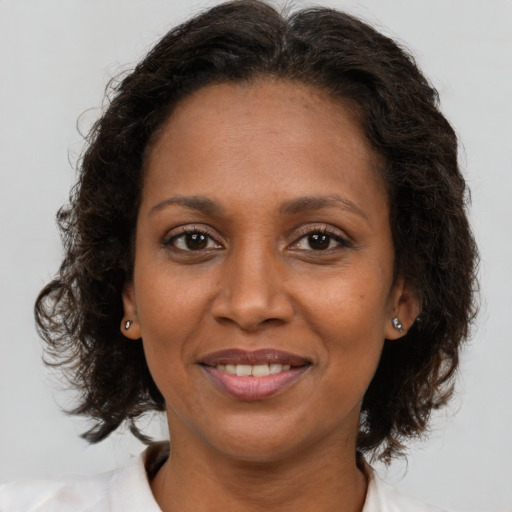 Joyful latino adult female with medium  brown hair and brown eyes