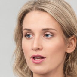 Joyful white young-adult female with medium  brown hair and blue eyes