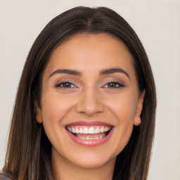 Joyful white young-adult female with long  brown hair and brown eyes