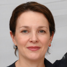 Joyful white adult female with medium  brown hair and grey eyes