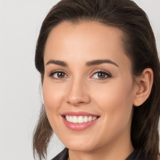 Joyful white young-adult female with long  brown hair and brown eyes