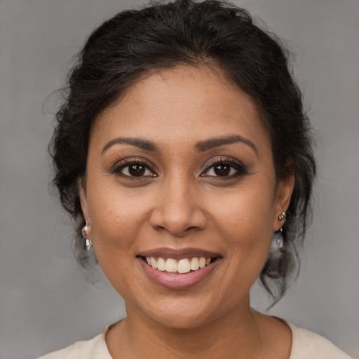 Joyful latino young-adult female with medium  brown hair and brown eyes