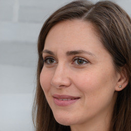 Joyful white adult female with long  brown hair and grey eyes