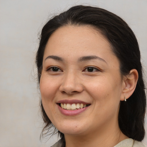 Joyful asian adult female with medium  brown hair and brown eyes