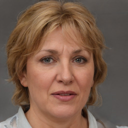 Joyful white adult female with medium  brown hair and blue eyes