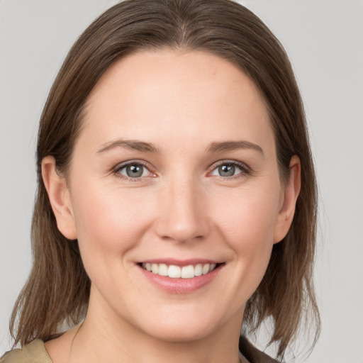 Joyful white young-adult female with medium  brown hair and grey eyes