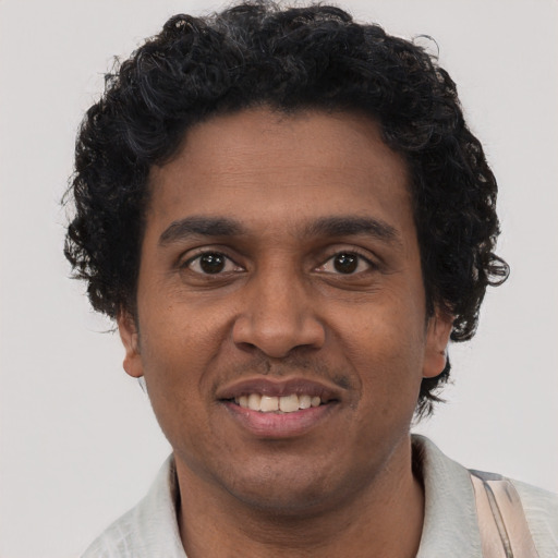 Joyful black adult male with short  black hair and brown eyes