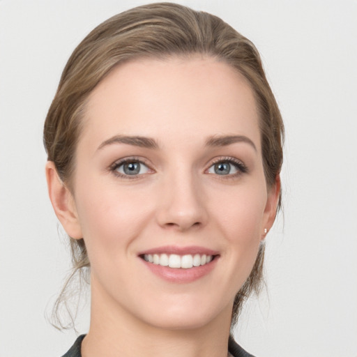 Joyful white young-adult female with medium  brown hair and grey eyes