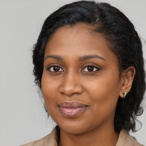 Joyful black young-adult female with long  black hair and brown eyes