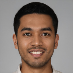 Joyful latino young-adult male with short  black hair and brown eyes