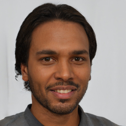 Joyful black young-adult male with short  black hair and brown eyes