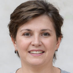 Joyful white young-adult female with medium  brown hair and grey eyes