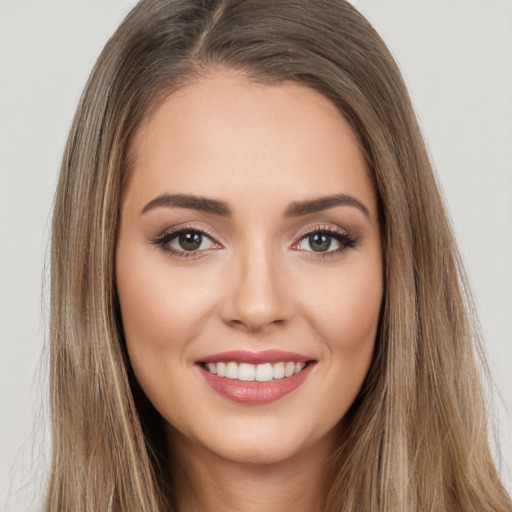 Joyful white young-adult female with long  brown hair and brown eyes