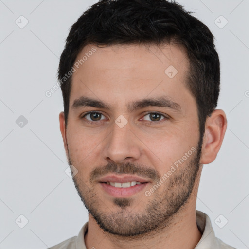 Joyful white young-adult male with short  black hair and brown eyes