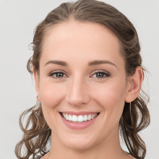 Joyful white young-adult female with medium  brown hair and blue eyes