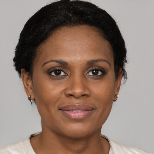 Joyful black adult female with short  brown hair and brown eyes