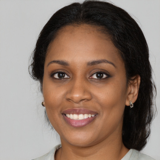 Joyful black young-adult female with medium  brown hair and brown eyes