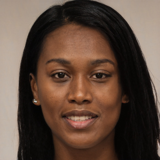 Joyful black young-adult female with long  black hair and brown eyes