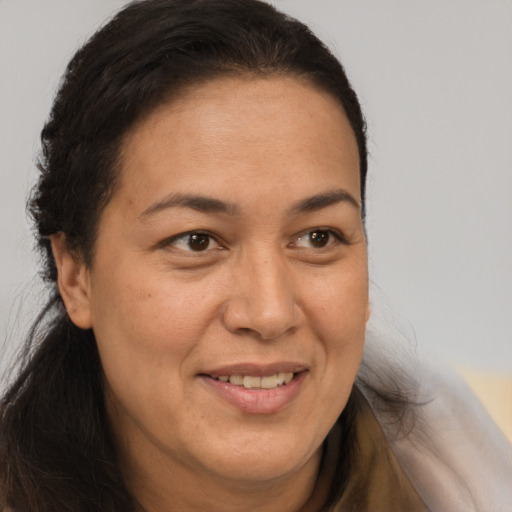 Joyful latino adult female with long  brown hair and brown eyes