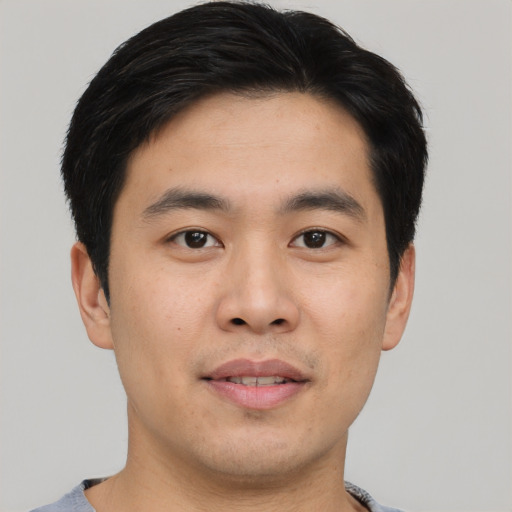 Joyful asian young-adult male with short  black hair and brown eyes