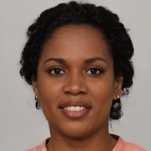 Joyful black young-adult female with short  black hair and brown eyes