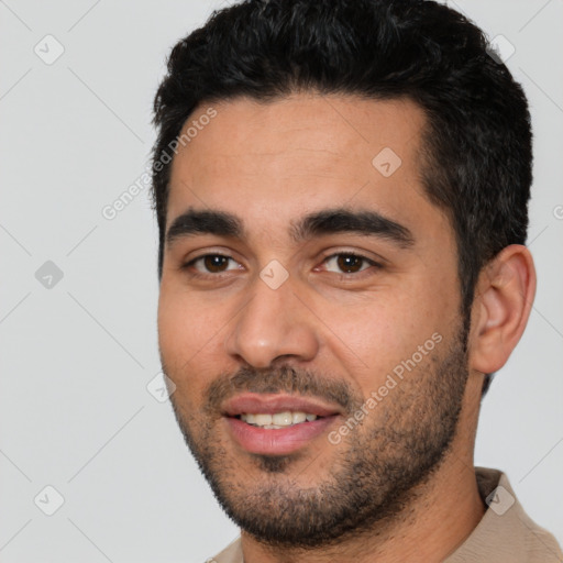 Joyful latino young-adult male with short  black hair and brown eyes