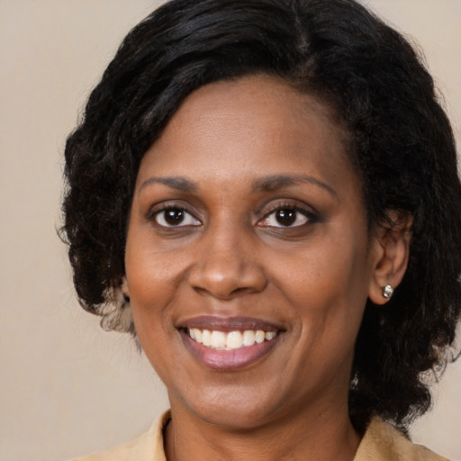 Joyful black adult female with medium  black hair and brown eyes