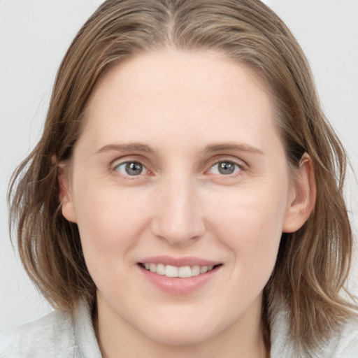 Joyful white young-adult female with medium  brown hair and blue eyes