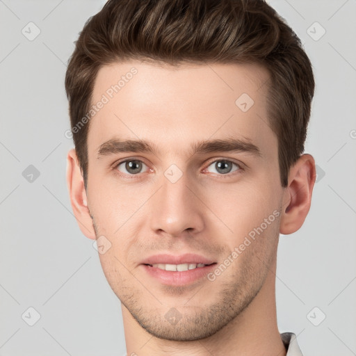 Joyful white young-adult male with short  brown hair and grey eyes