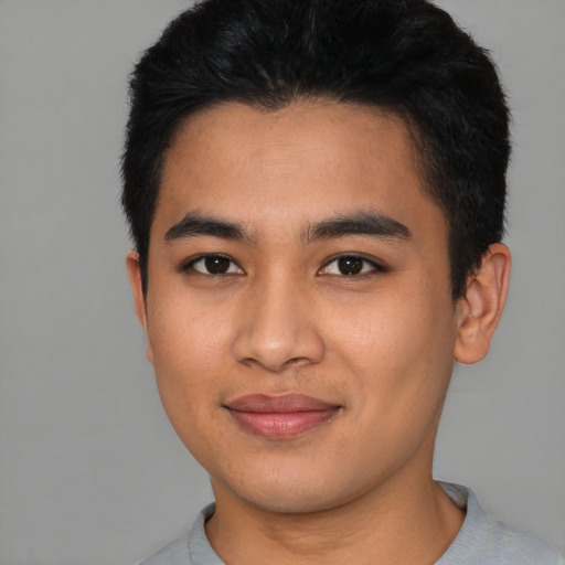 Joyful asian young-adult male with short  black hair and brown eyes