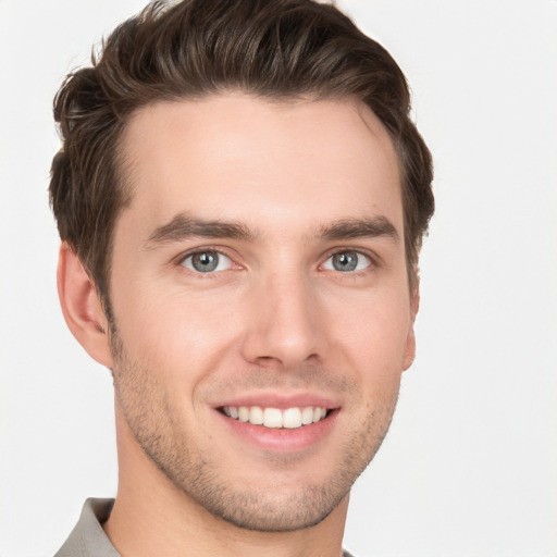 Joyful white young-adult male with short  brown hair and grey eyes