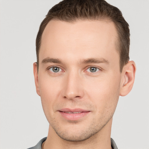 Joyful white young-adult male with short  brown hair and grey eyes