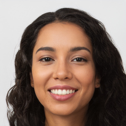 Joyful latino young-adult female with long  brown hair and brown eyes