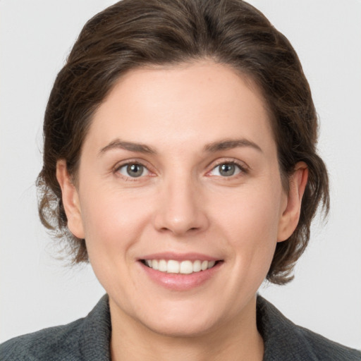 Joyful white young-adult female with medium  brown hair and grey eyes