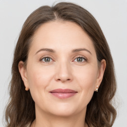 Joyful white adult female with medium  brown hair and grey eyes