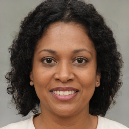 Joyful black adult female with medium  brown hair and brown eyes