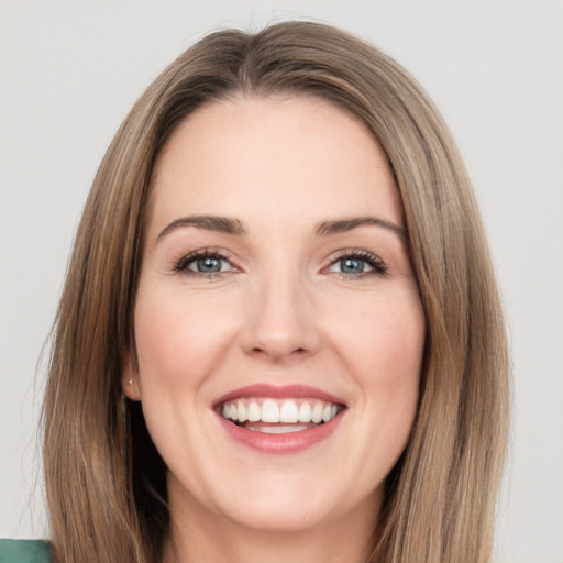 Joyful white young-adult female with long  brown hair and green eyes