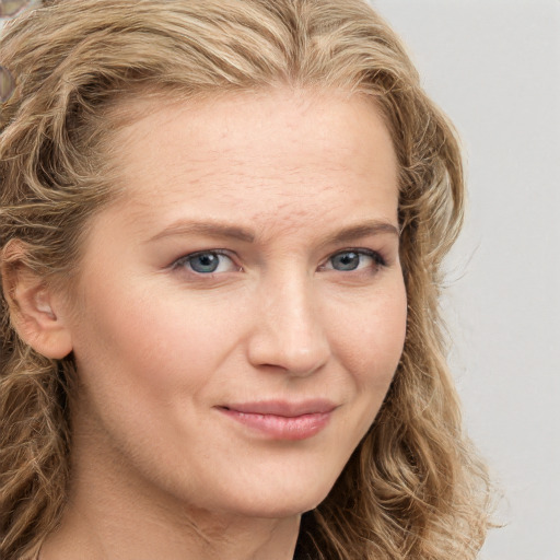 Joyful white young-adult female with long  brown hair and blue eyes