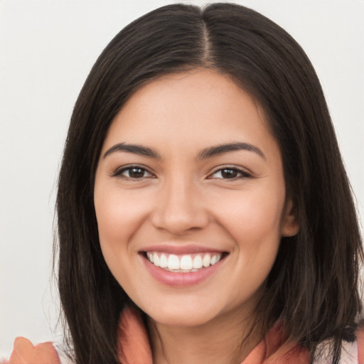 Joyful latino young-adult female with long  brown hair and brown eyes