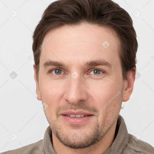 Joyful white young-adult male with short  brown hair and grey eyes